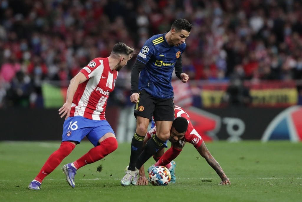 Ronaldo trong vòng vây của hai cầu thủ Atletico Madrid.