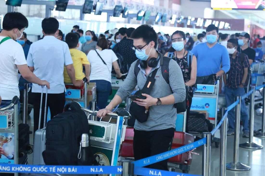 Hành khách xếp hàng ngay ngắn chờ làm thủ tục tại sân bay. Ảnh: Quang Vinh.