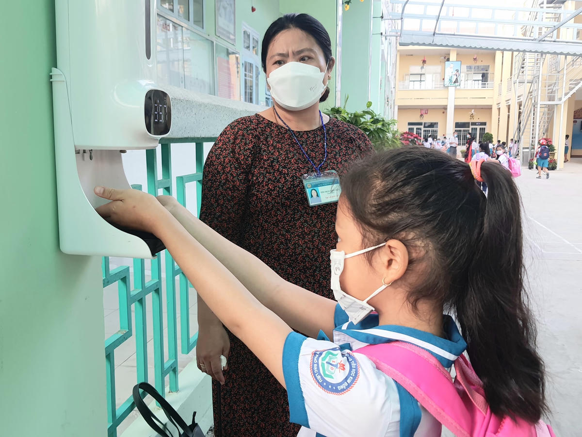Học sinh rửa tay sát khuẩn, đo thân nhiệt trước khi vào lớp học.