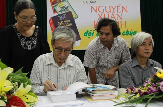 Nhà văn Nguyễn Xuân Khánh ký tặng sách bạn văn. Ảnh tư liệu.