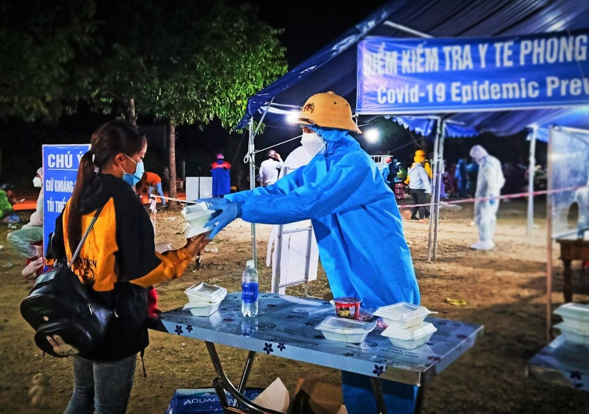 Lực lượng chức năng tiếp tế thức ăn cho bà con trên đường về quê.