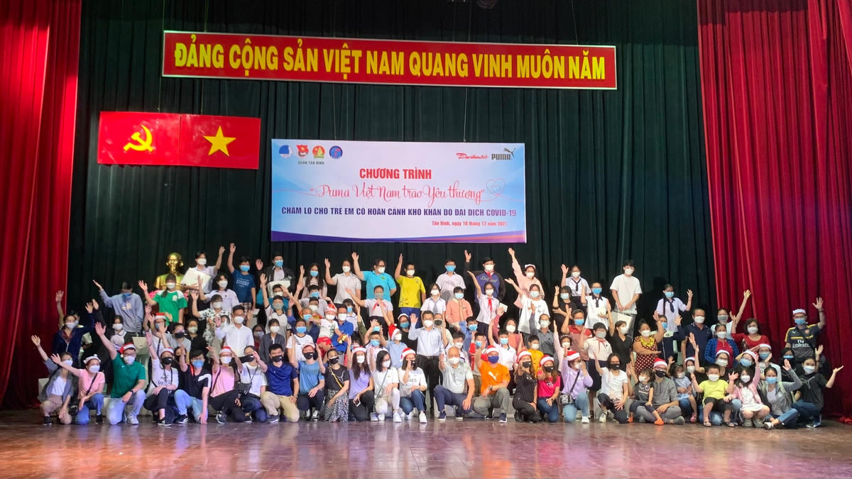 Nhà báo Chu Ninh, Trưởng ban Đại diện Báo Đại Đoàn Kết cùng Quận Đoàn quận Tân Bình và Đại diện Tập đoàn Puma tại Việt Nam chụp ảnh lưu niệm với  các trẻ em bị mồ côi vì Covid-19 tại quận Tân Bình.