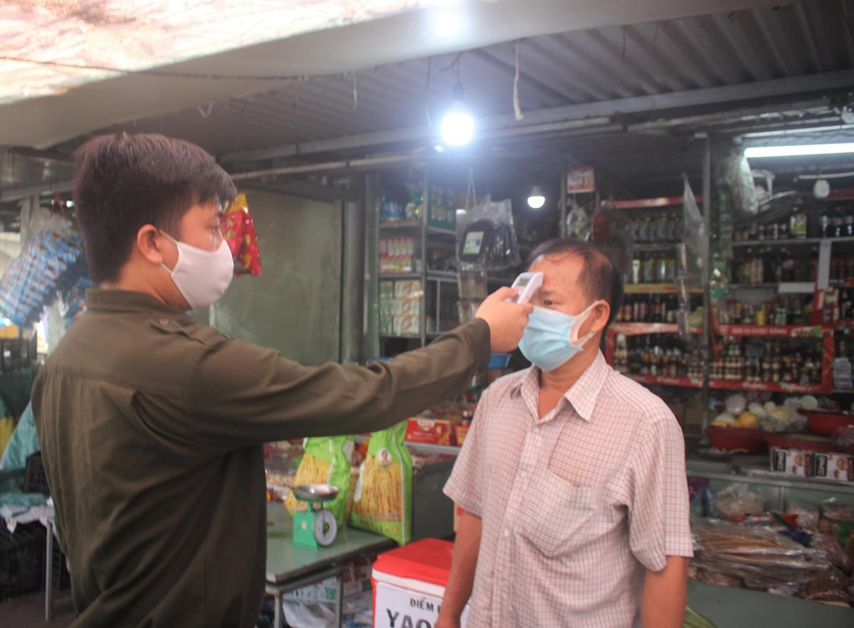 Đo thân nhiệt người dân vào chợ.