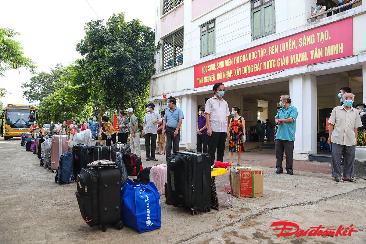 Các công dân được xuống theo từng đợt, xếp thành hai hàng, hành lý để ở giữa để thực hiện phun khử khuẩn. Ảnh: Quang Vinh.