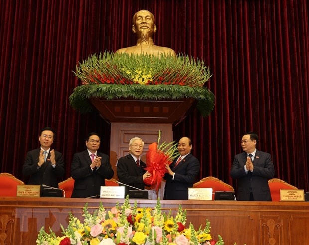 Thay mặt Bộ Chính trị, đồng chí Nguyễn Xuân Phúc, Thủ tướng Chính phủ tặng hoa chúc mừng đồng chí Nguyễn Phú Trọng được tín nhiệm bầu làm Tổng Bí thư Ban Chấp hành Trung ương Đảng Cộng sản Việt Nam khóa XIII. (Ảnh: Trí Dũng/TTXVN).