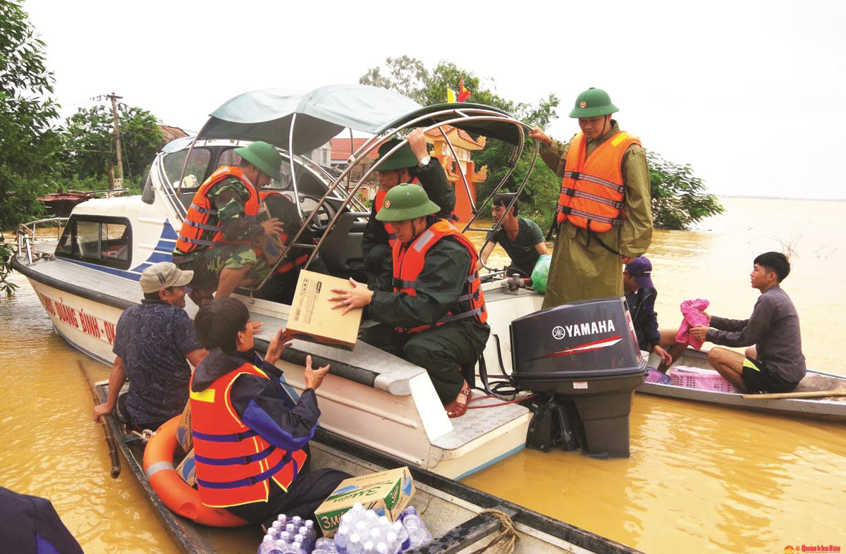 Cán bộ, chiến sĩ Ban Chỉ huy quân sự huyện Quảng Ninh (Quảng Bình) vượt lũ hỗ trợ lương thực cho người dân xã Tân Ninh.