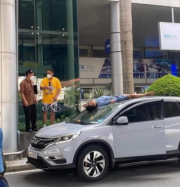 Anh V.V.H. nằm bất động vài phút trên nóc chiếc ô tô 5 chỗ sau khi nhảy xuống từ lầu 2. 