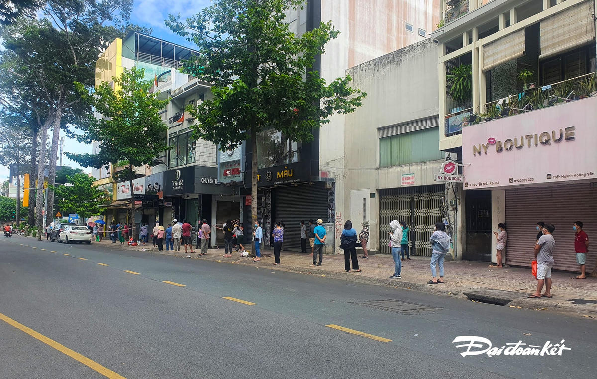 Người dân xếp hàng giãn cách cách điểm tiêm Trường mầm non Vàng Anh (phường 2, Quận 5).