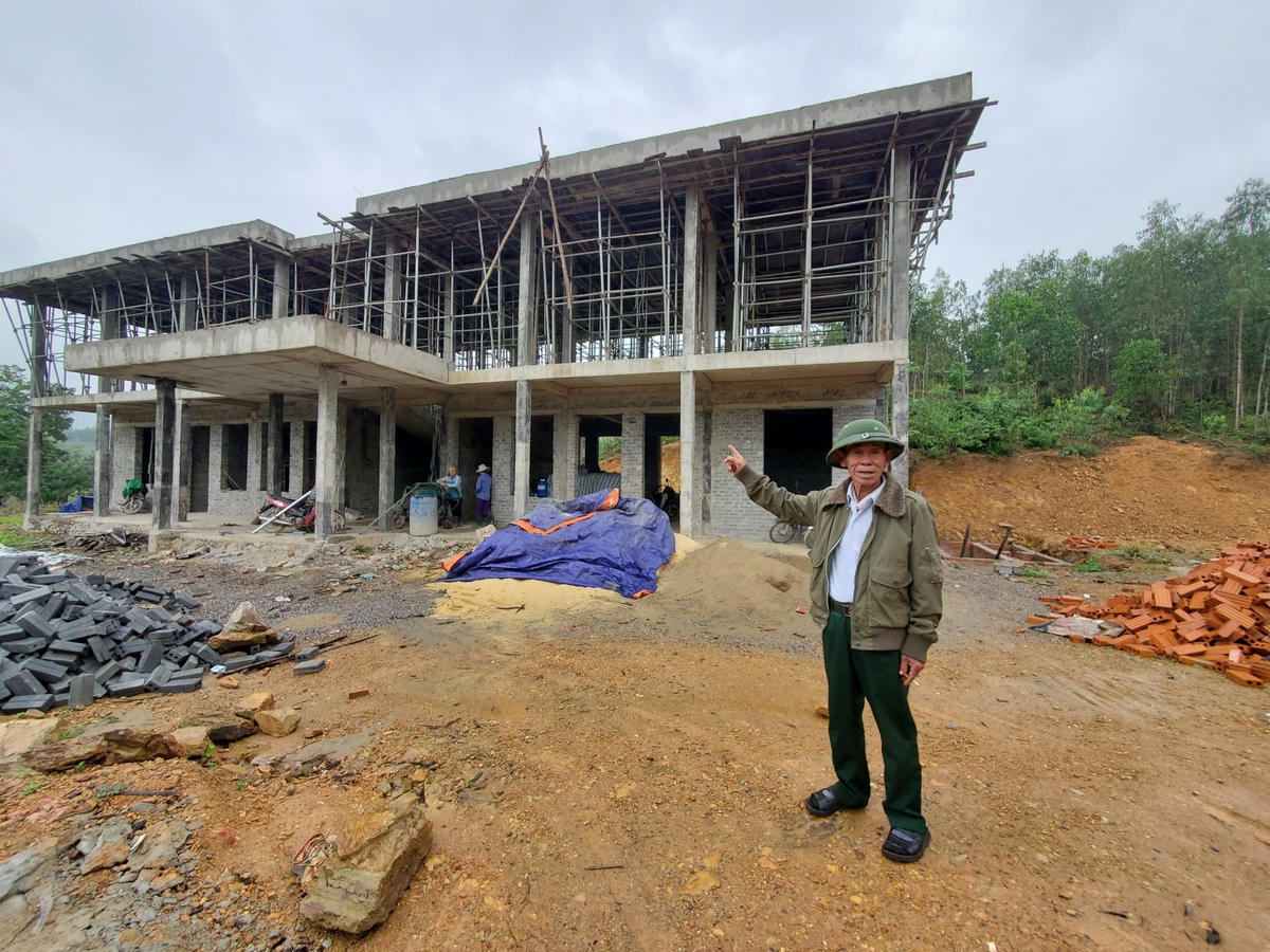 Ông Hồ Hơn vui mừng bên ngôi trường mới được xây dựng trên nền đất do gia đình hiến tặng.