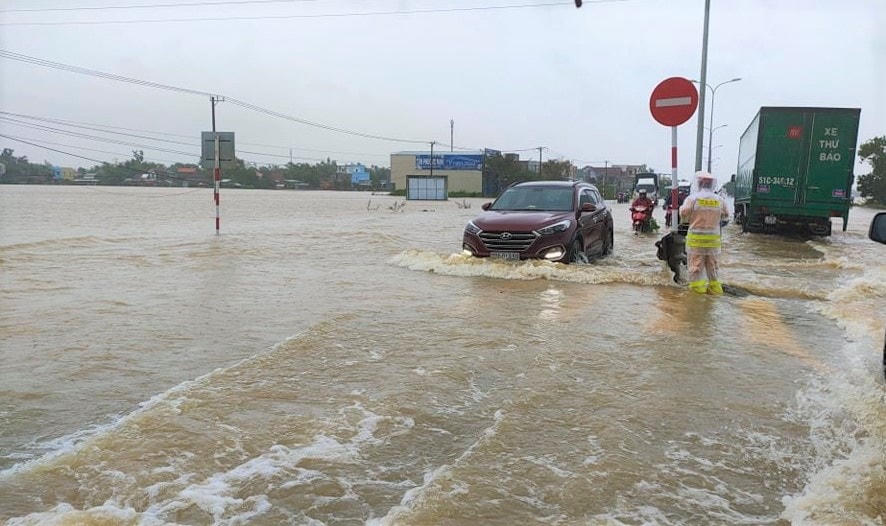 CSGT hướng dẫn phương tiện vượt Qua lộ 1A bị ngập lũ.