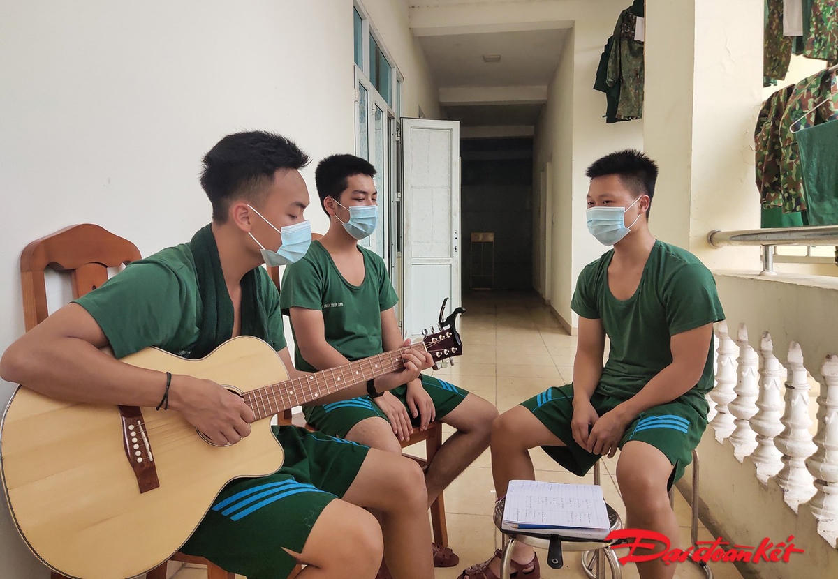 Sau khi kết thúc công việc hàng ngày, các chiến sỹ tranh thủ ngồi nghỉ ngơi, cùng đánh đàn và hát. Ảnh: Quang Vinh. 
