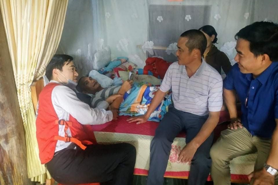 Thầy giáo Ngô Mậu Tình (áo đỏ) trong một lần trao hỗ trợ cho người có hoàn cảnh khó khăn, bệnh tật.