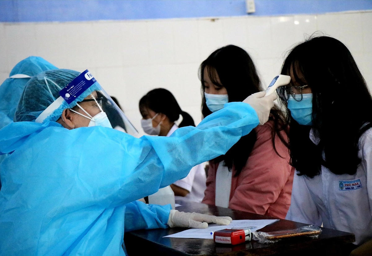 Trước khi tiêm vaccine, các em học sinh đều được khám sàng lọc và đo thân nhiệt.