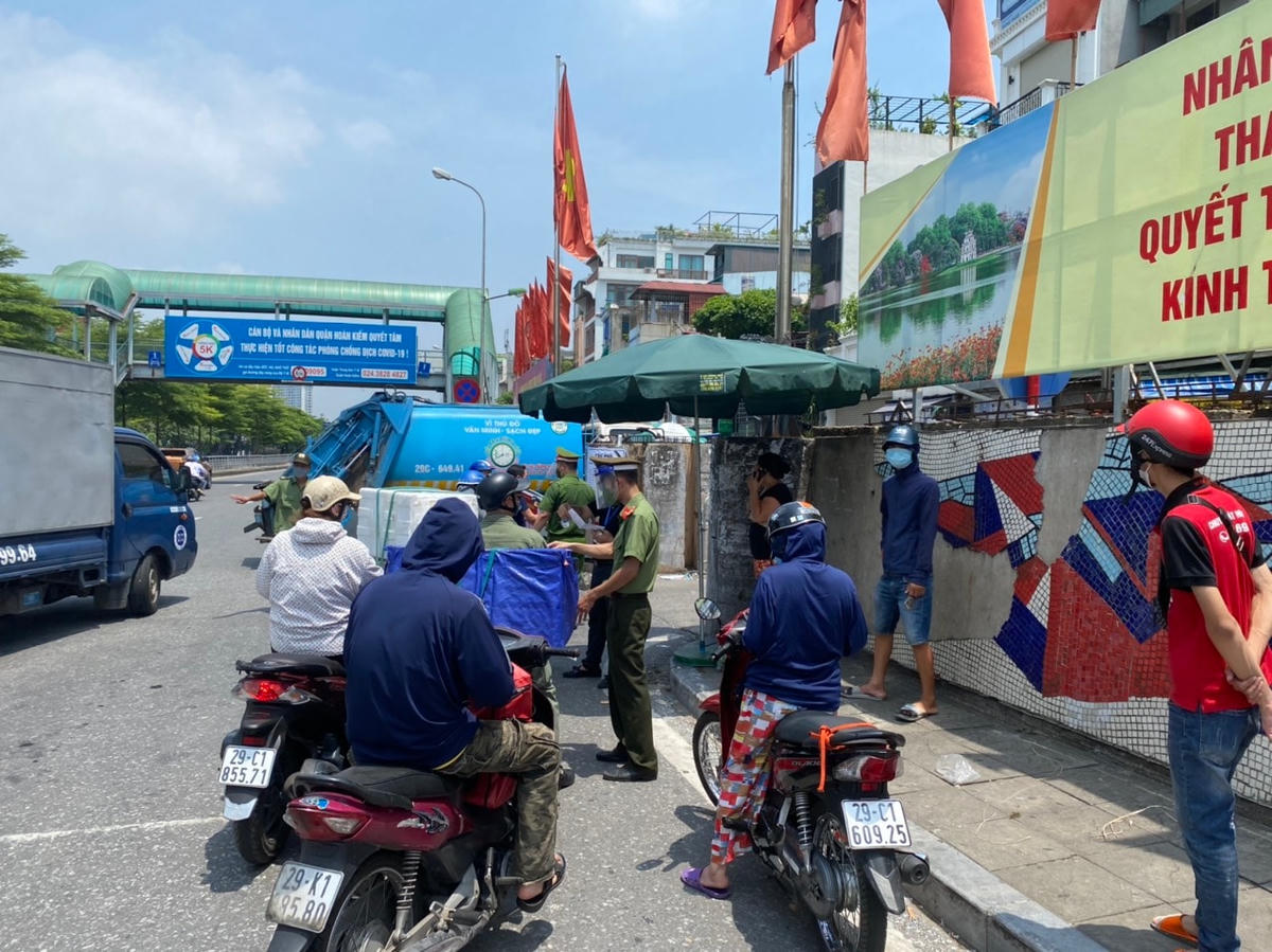 Nhiều người dân có mặt tại các chốt kiểm soát, muốn di chuyển vào địa bàn phường Chương Dương nhưng lực lượng chức năng giải thích và yêu cầu thực hiện đúng quy định. Trong trường hợp gửi đồ cho người thân, lực lượng chức năng sẽ nhận và để tại bàn, người được gửi đồ sẽ được thông báo ra lấy hoặc có lưc lượng hỗ trợ đưa vào. Ảnh: Toàn Nghĩa. 