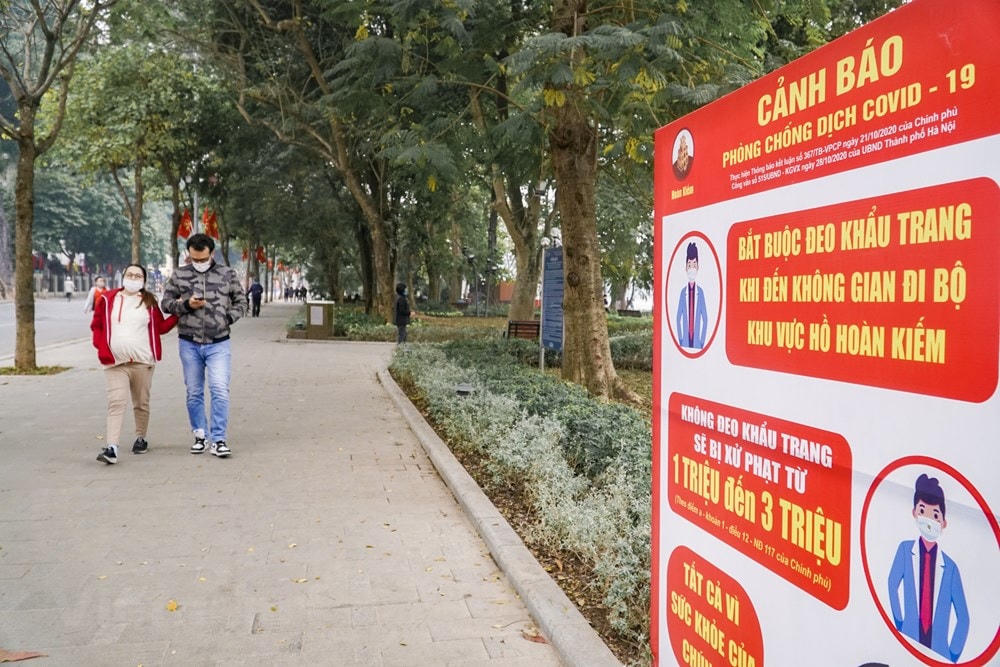 Mặc dù vắng người lui tới nhưng những biển khuyến cáo người dân tuân thủ nghiêm túc các biện pháp phòng dịch Covid-19, đặc biệt là đeo khẩu trang vẫn được lực lượng chức năng đặt ở ngay khu vực ra vào phố đi bộ. (Ảnh: Minh Hiếu/Vietnam+).
