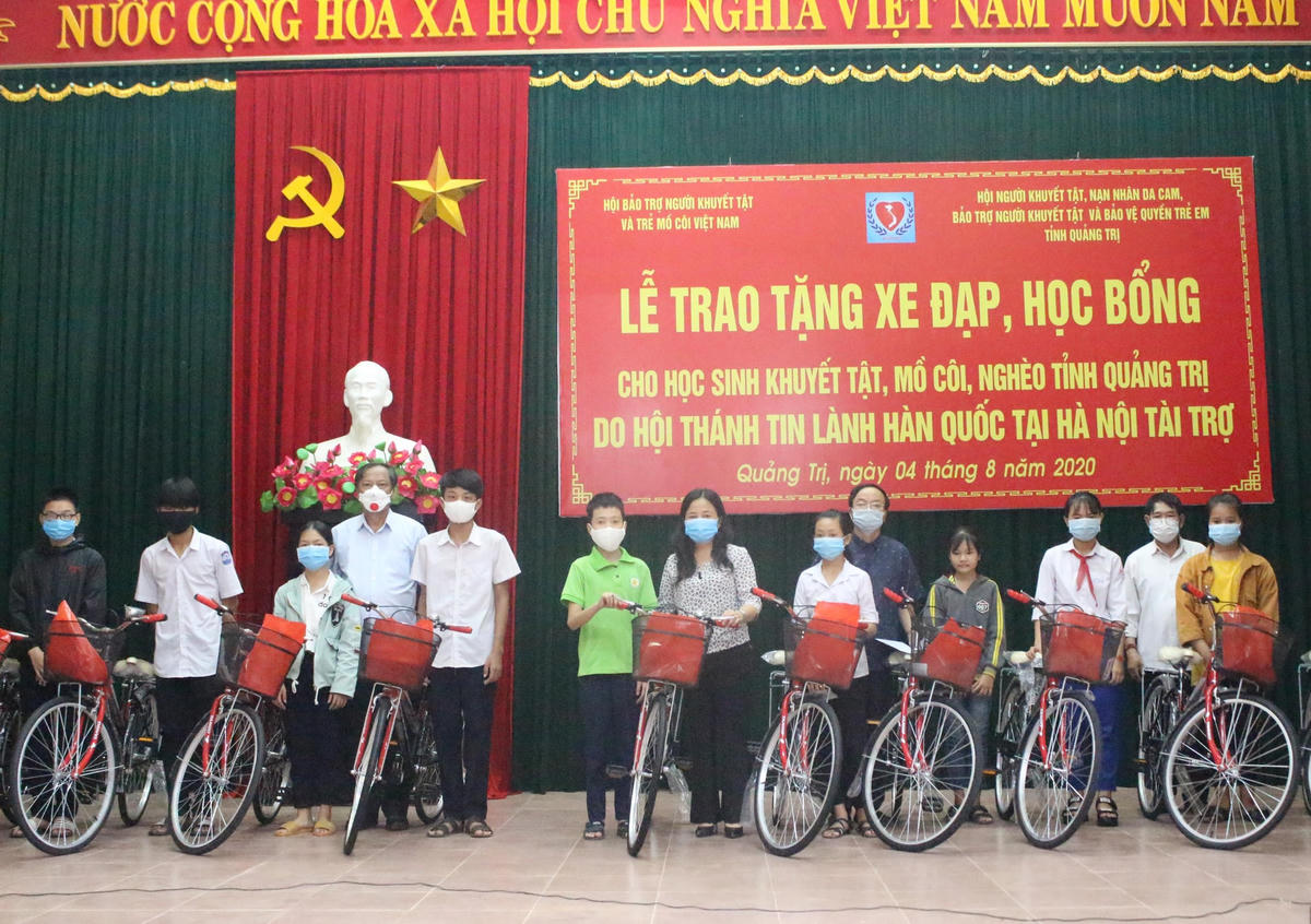 Bà Lê Thị Lan Hương (giữa) trao xe đạp cho các em học sinh có hoàn cảnh khó khăn.