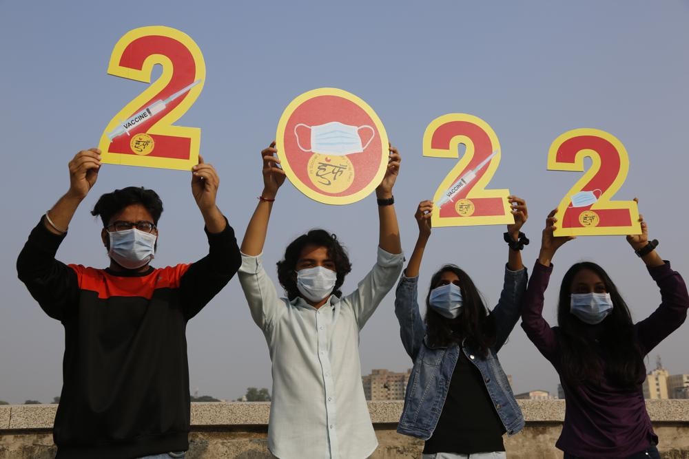 Người dân Ấn Độ cầm trên tay những tấm bìa để chào đón năm 2022 vào đêm giao thừa ở Ahmedabad, Ấn Độ. Ảnh AP.