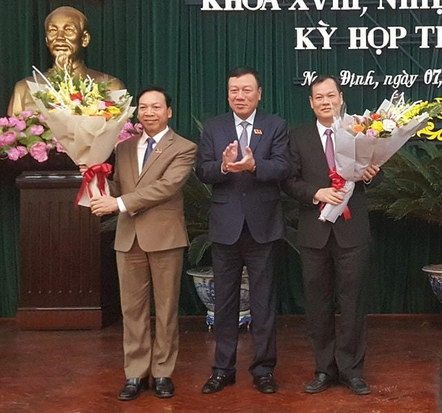 Ở khối chính quyền, sau đại hội, Nam Định mới chỉ kiện toàn được chức danh Chủ tịch HĐND tỉnh trong khi 2 chức danh Phó Chủ tịch HĐND tỉnh và 1 chức danh Phó Chủ tịch UBND tỉnh chưa được kiện toàn. Trong ảnh: Bí thư Tỉnh ủy Nam Định Đoàn Hồng Phong tặng hoa, chúc mừng ông Trần Văn Chung (trái), nguyên Chủ tịch HĐND tỉnh hoàn thành nhiệm vụ, ông Lê Quốc Chỉnh (phải) nhận nhiệm vụ Chủ tịch HĐND tỉnh.