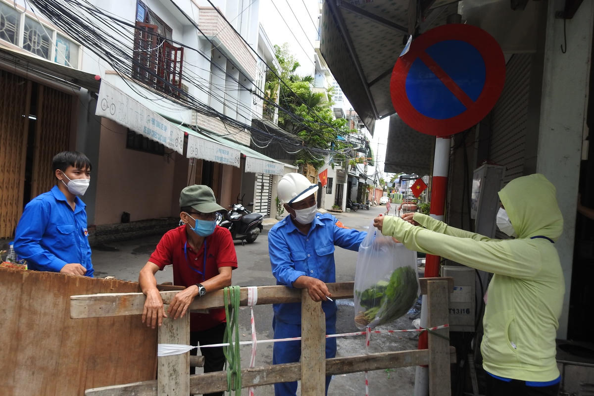 Lương thực, thực phẩm được thành viên tổ Covid-19 cộng đồng vùng xanh tiếp nhập, khử khuẩn an toàn trước khi giao cho các hộ  dân. Ảnh: Thanh Tùng.