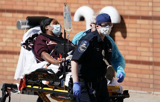 Nhân viên y tế chuyển bệnh nhân mắc Covid-19 vào một bệnh viện ở New York, Mỹ. Ảnh: AFP.