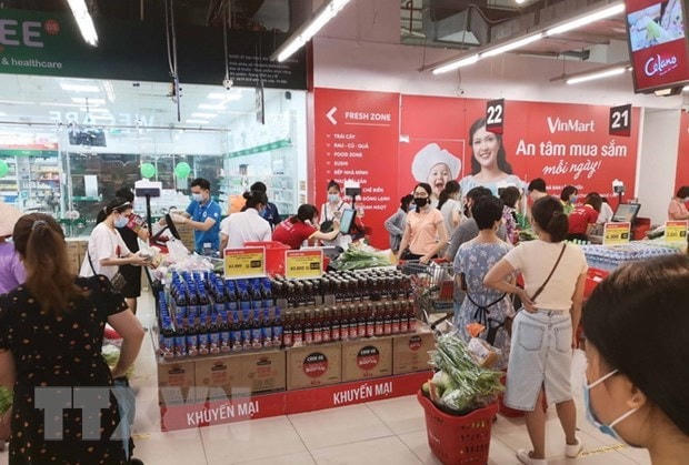 Người dân đi mua sắm tại siêu thị VinMart-Times City sáng 24/7 vừa qua. Ảnh: Thanh Tùng/TTXVN.