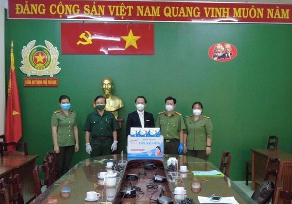 Ông Jutin H.T. Bui trao khẩu trang y tế cho đại diện Công an thành phố Thủ Đức.