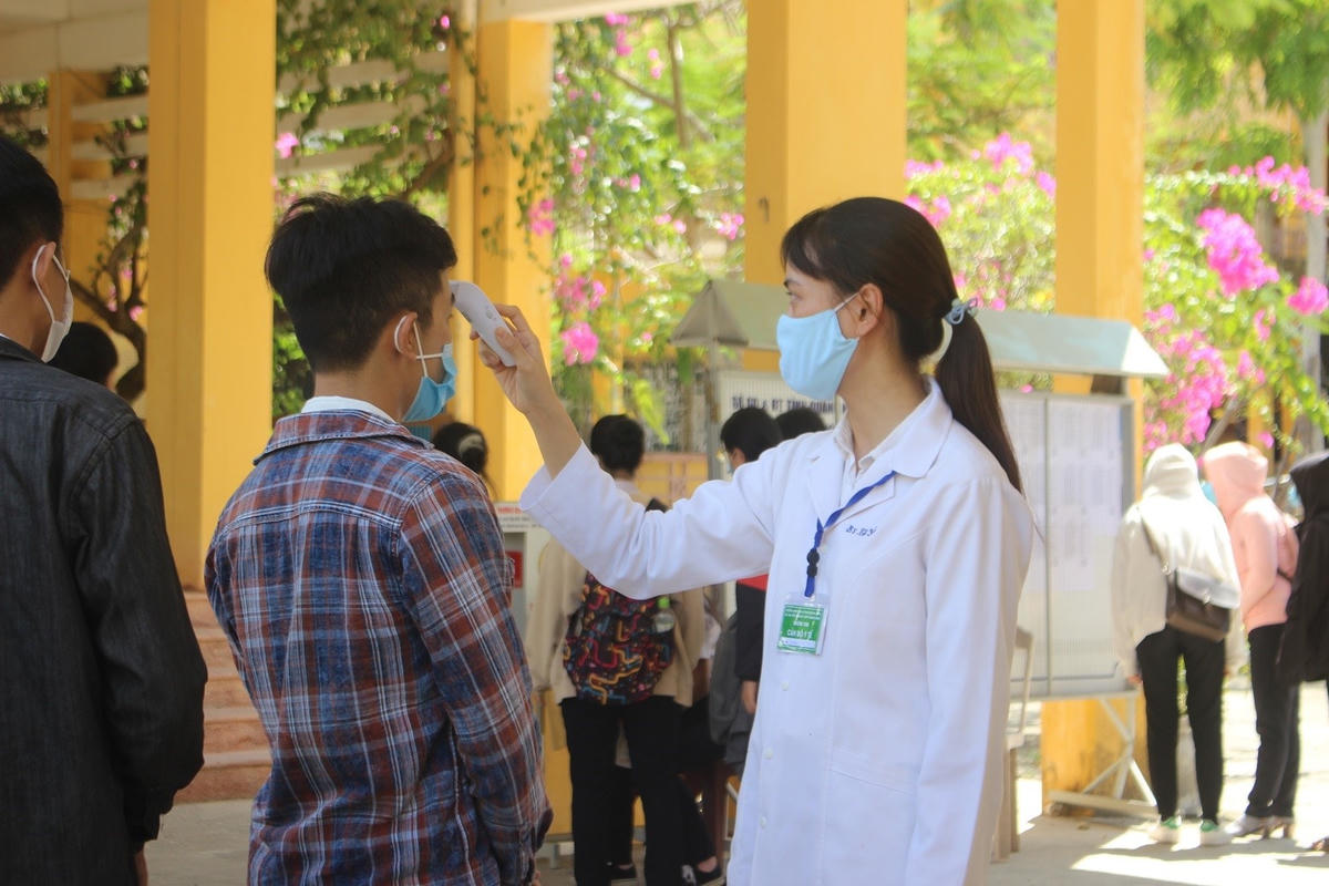Đo thân nhiệt các thí sinh dự thi tốt nghiệp THPT năm 2020.