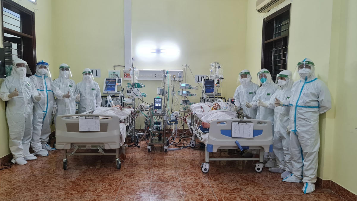 Y bác sĩ vui vẻ và nỗ lực chăm sóc bệnh nhân Covid-19.