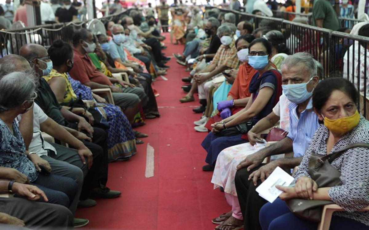 Người dân chờ tiêm vaccine tại thành phố Mumbai, Ấn Độ. Ảnh: AP.  