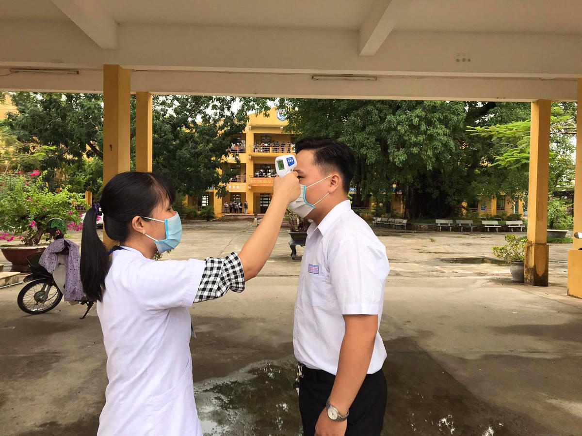 Nhân viên y tế kiểm tra thân nhiệt cho thí sinh.