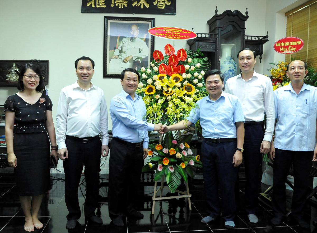 Phó Chủ tịch - Tổng Thư ký Hầu A Lềnh tặng hoa chúc mừng Báo Người Công giáo. (Ảnh Mạnh Cường).