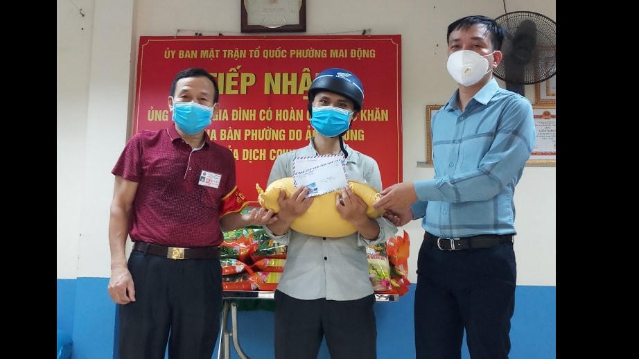 Ông Nguyễn Ngọc Hiển (bên phải) hỗ trợ gạo cho người dân gặp khó khăn.