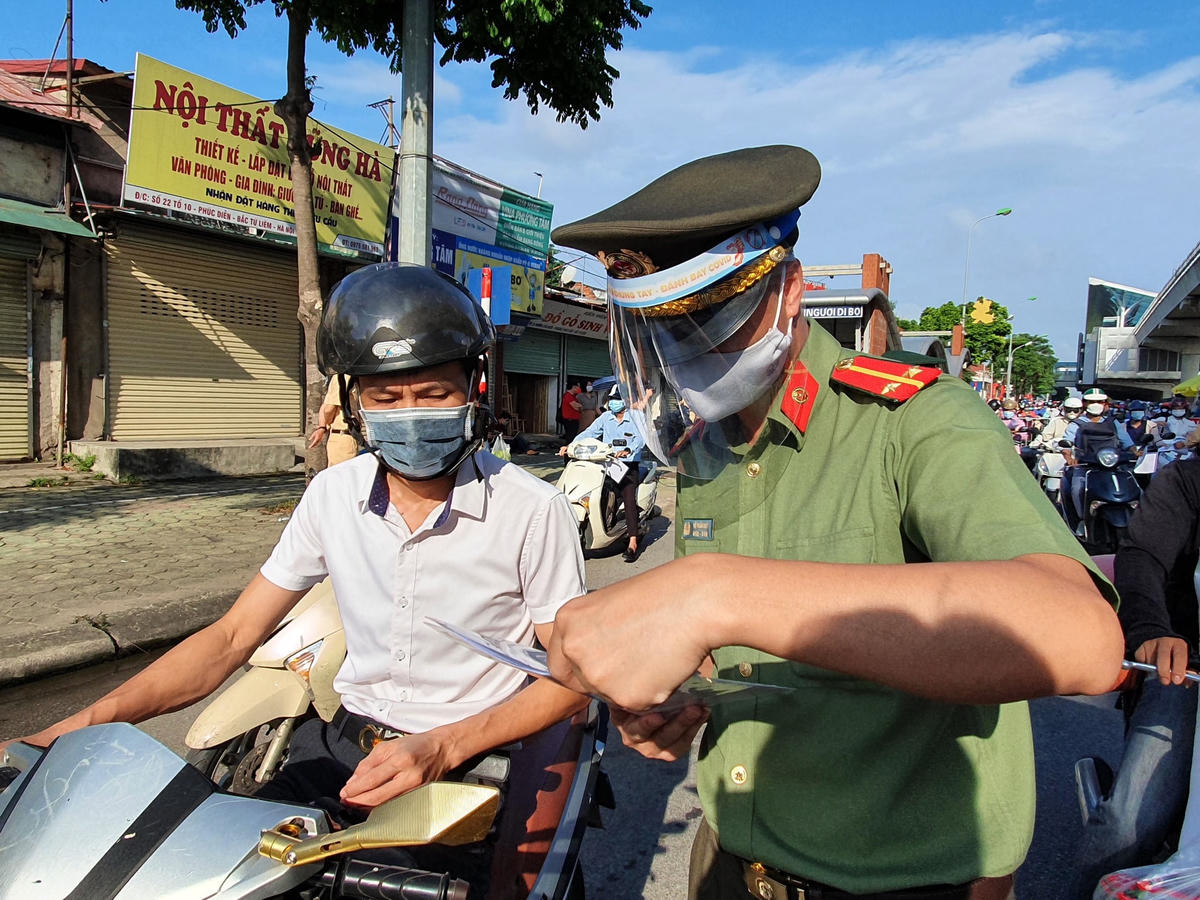 Lực lượng chức năng kiểm tra giấy đi đường của người dân Hà Nội. Ảnh minh họa: Hoàng Chiến.
