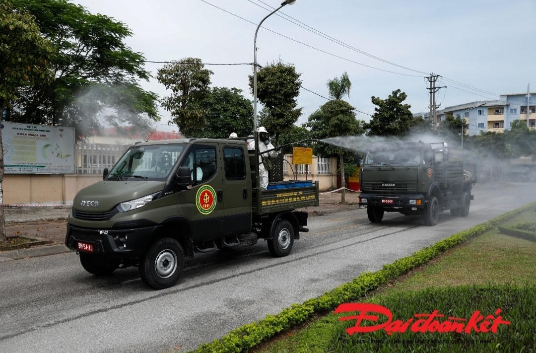 Các chiến sỹ phun khử khuẩn toàn bộ khu vực đường sá xung quanh Bệnh viện Bệnh Nhiệt đới Trung ương cơ sở Đông Anh. Ảnh: Quang Vinh. 