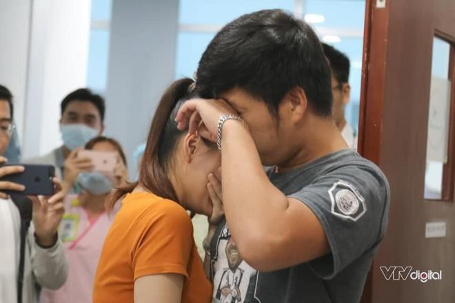Bố mẹ của Trúc Nhi - Diệu Nhi ôm nhau khóc bên ngoài cửa phòng mổ ngay khi giường 2 bé được đẩy vào phía trong. (Ảnh: VTV Digital).