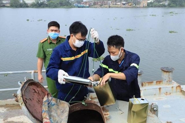 Công an lấy mẫu xăng trên phương tiện thủy các đối tượng đang vận chuyển. Ảnh: CAĐN