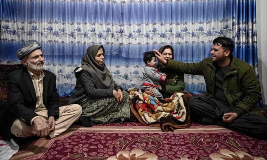 3: Hamid Safi (bên phải), tài xế taxi tìm thấy Sohail Ahmadi tại sân bay Kabul, vỗ về đứa trẻ sơ sinh cùng với ông nội Mirza Mohammad Qasemi và những người khác sau khi cậu bé trở về với người thân.  