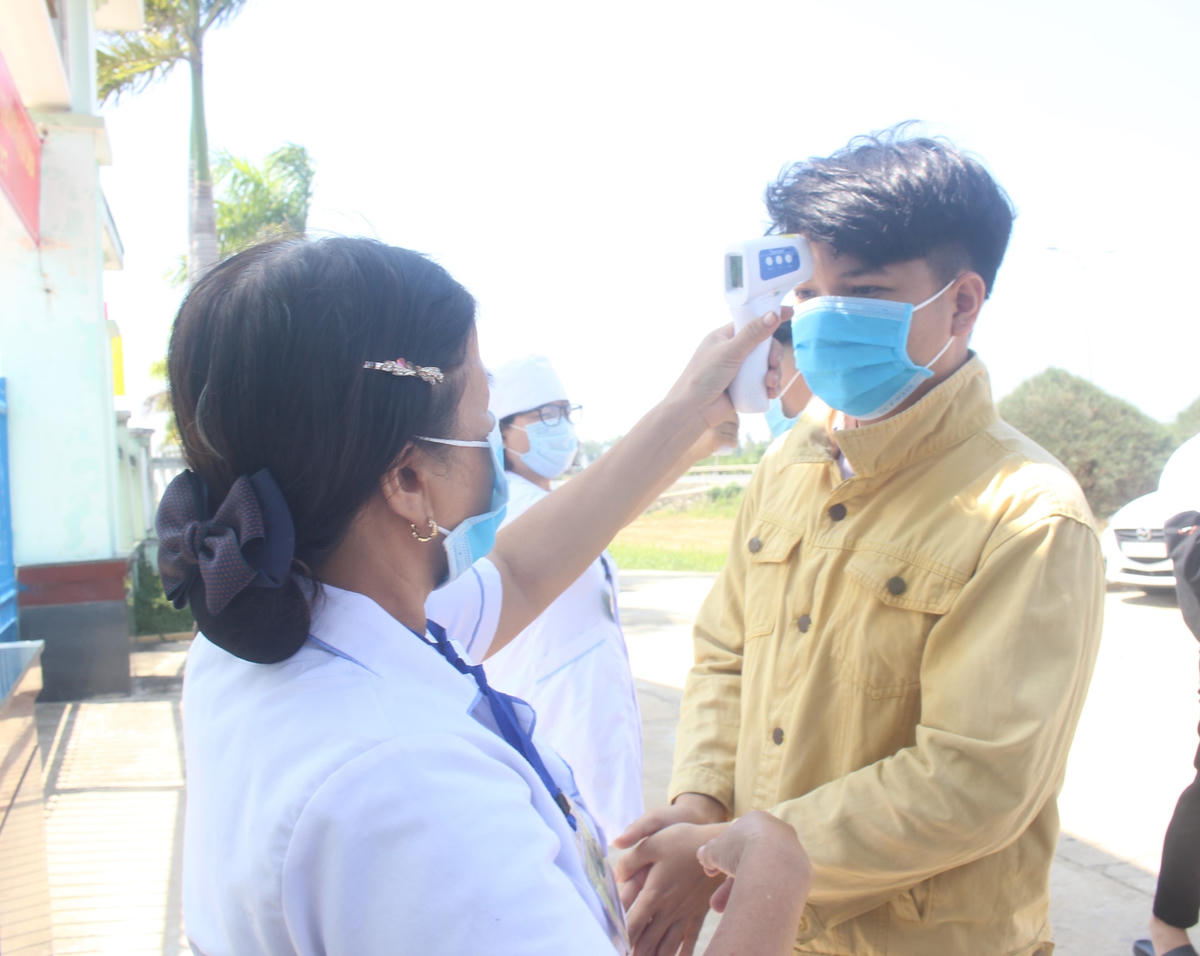 Các thí sinh làm thủ tục dự thi tốt nghiệp THPT đợt 2 đo thân nhiệt.