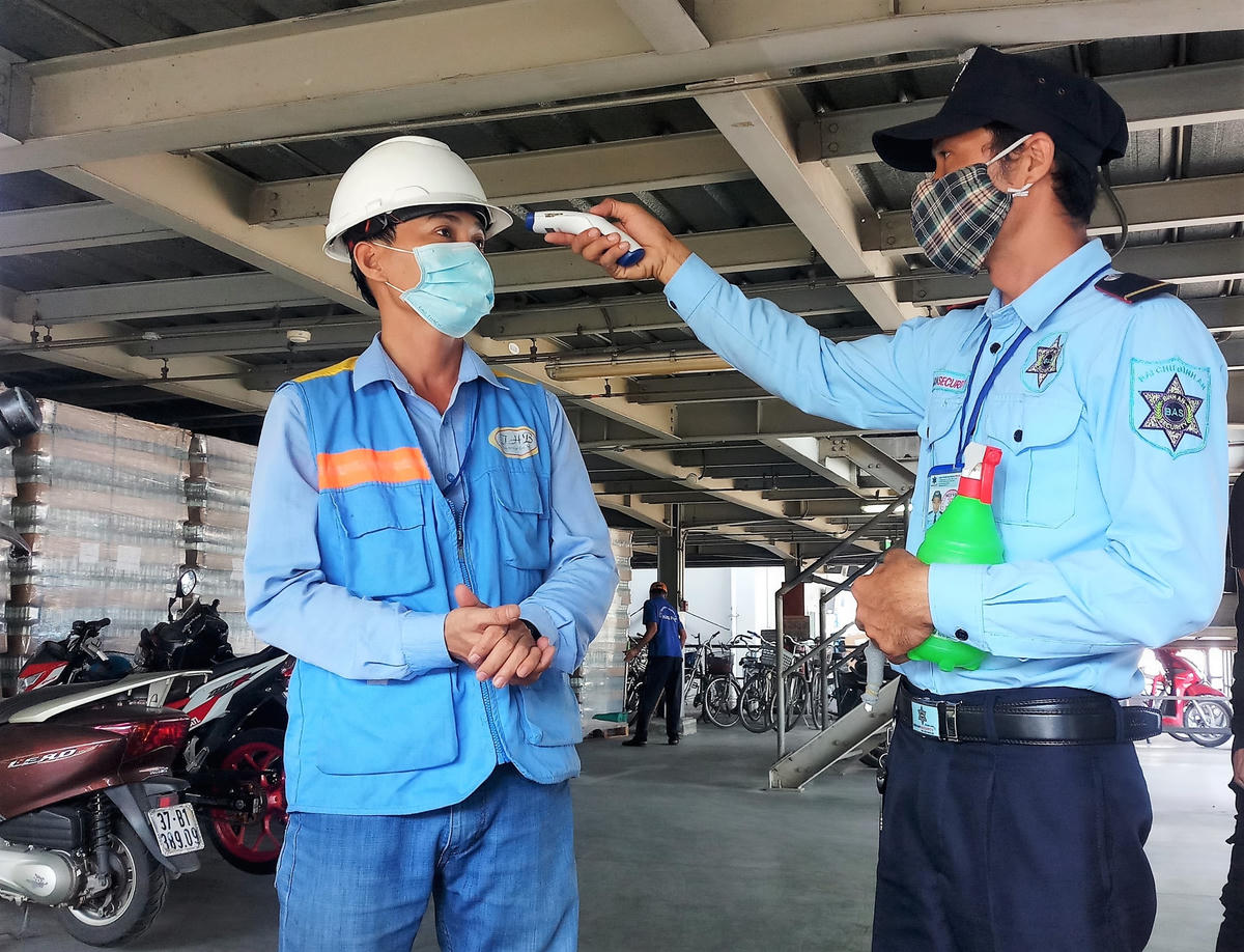 Đo nhiệt độ cho nhân viên trước khi vào ca.