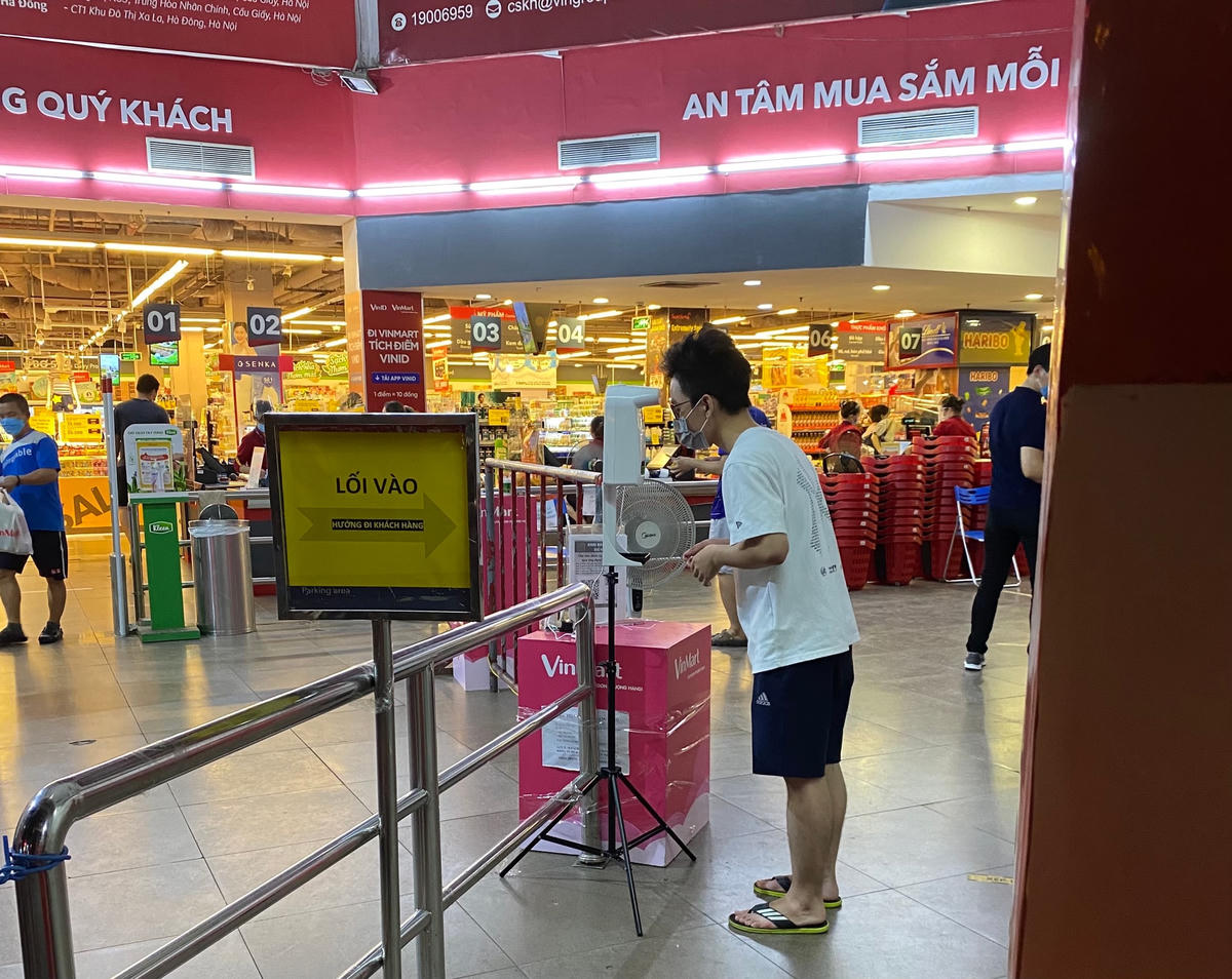 Tất cả khách hàng phải thực hiện khai báo y tế, sau đó đo thân nhiệt và sát khuẩn tay. Ảnh: L.A..
