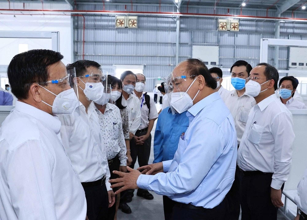 Chủ tịch nước Nguyễn Xuân Phúc thăm hỏi, động viên đội ngũ cán bộ, nhân viên y tế. (Ảnh: Thống Nhất/TTXVN).