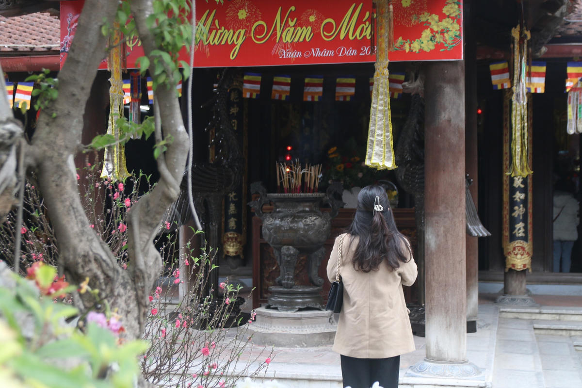 Phút thành tâm lặng lẽ của một bạn trẻ giữa không gian khói hương nghi ngút tại chùa Hà ngày Lễ Tình nhân.