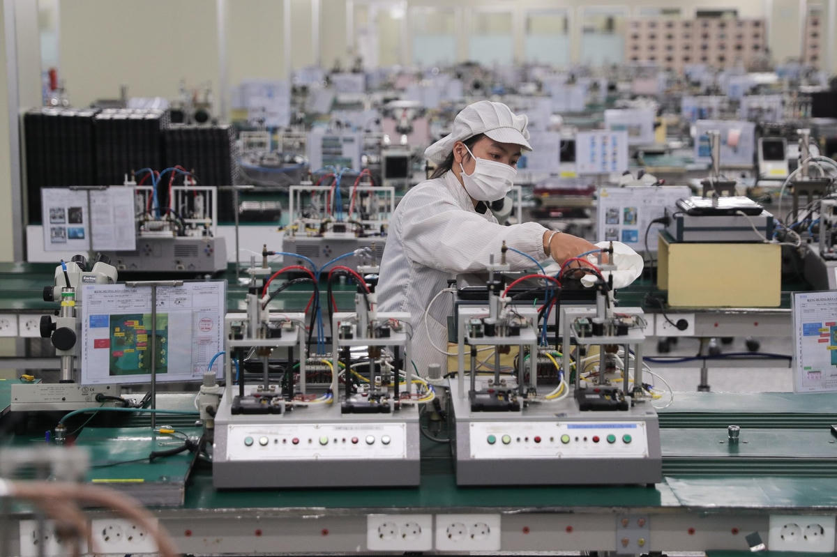 Công nhân công ty Hosiden lau máy móc, chuẩn bị cho hoạt động trở lại sản xuất.