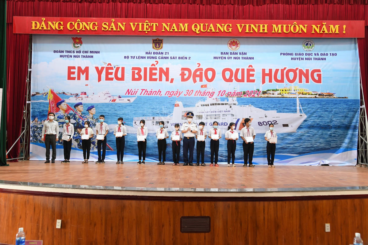 Thượng tá Bùi Đại Hải, phó Chính ủy BTL Vùng CSB 2 trao học bổng cho các em học sinh.