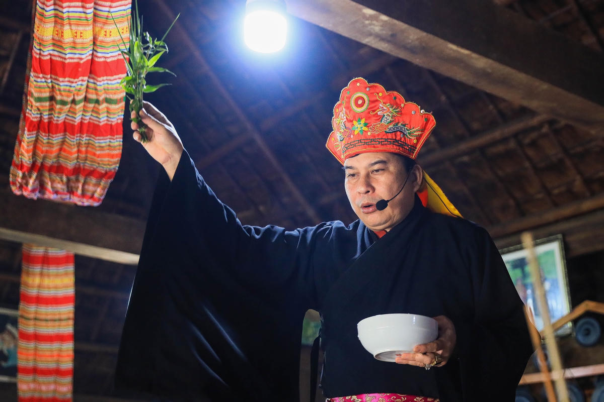 Thầy mo vẩy nước mát cho gia chủ. Ảnh: Quang Vinh. 