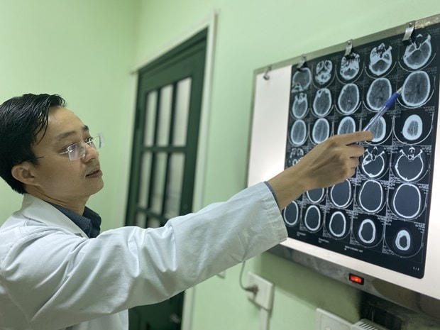 Tiến sỹ Bùi Huy Mạnh xem phim chụp của bệnh nhân. (Ảnh: Vietnam+).