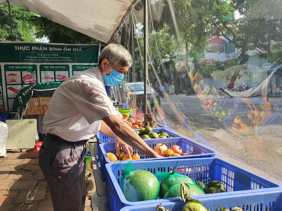 Ông Trần Ngọc Tuấn đang sắp xếp lại gian hàng...