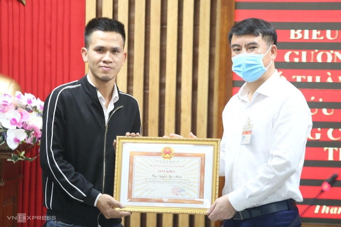 Đại diện lãnh đạo quận Thanh Xuân tặng bằng khen cho anh Nguyễn Ngọc Mạnh. Ảnh: Gia Chính.