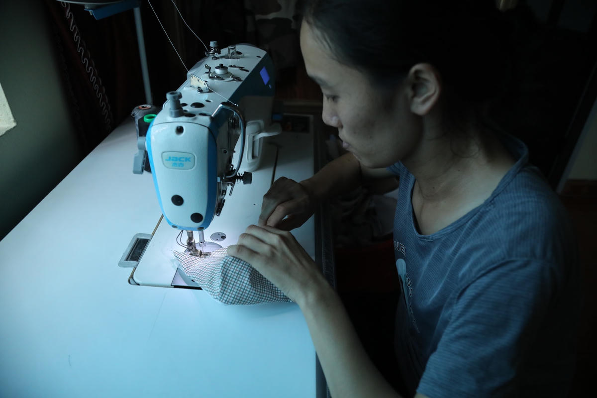 Chị Vũ Thị Tuyết bên chiếc máy khâu do Mặt trận trao tặng. Ảnh: Quang Vinh.