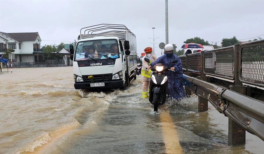 CSGT giúp dân đi qua đoạn ngập nước ở Quốc lộ 1A.